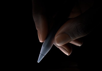 用户用拇指和食指握住 Apple Pencil Pro 靠下三分之一左右的位置，做出书写姿势。